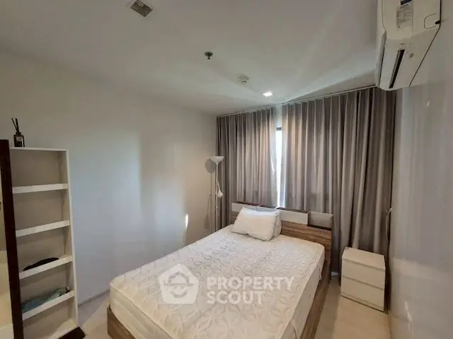 Modern bedroom with cozy bed, air conditioning, and ample natural light.