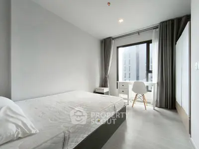 Modern minimalist bedroom with large window and sleek furniture in a high-rise apartment.