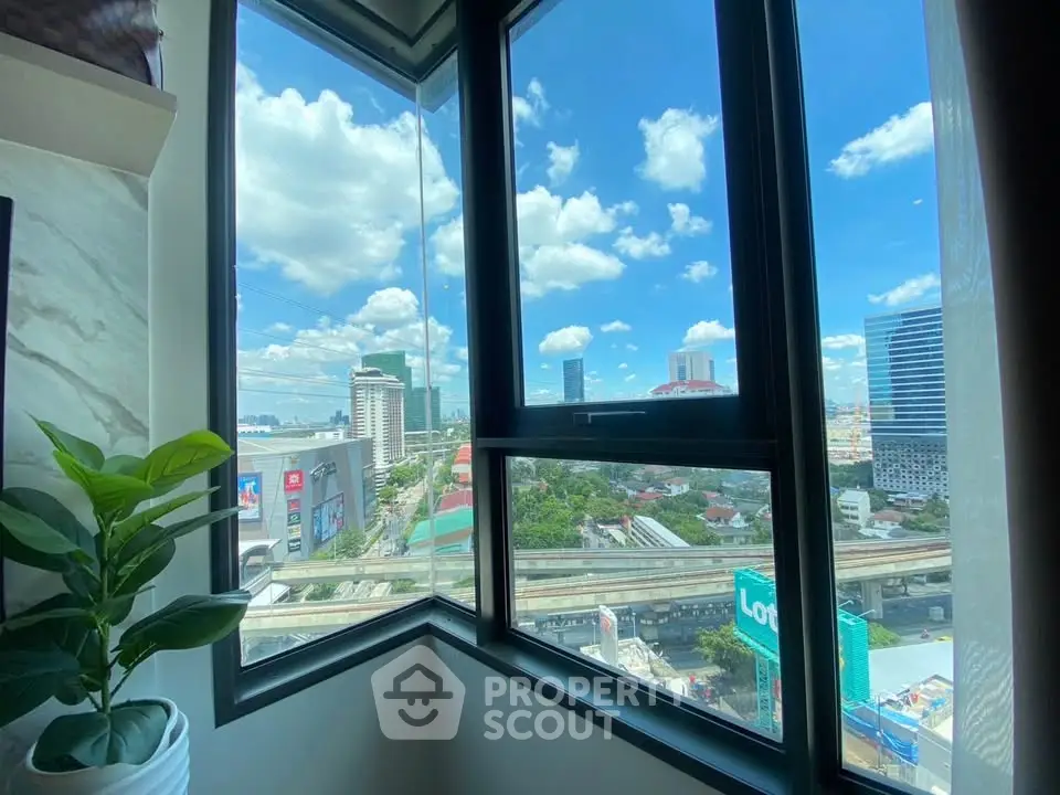 Stunning city view from a modern apartment corner window with clear blue skies.