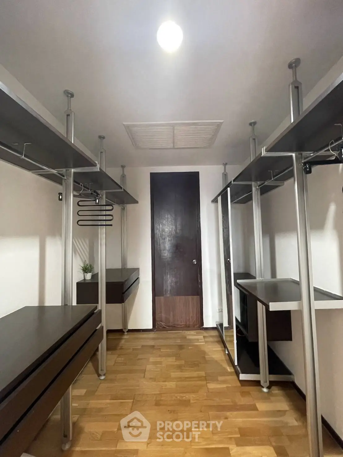 Spacious walk-in closet with modern shelving and hardwood floors