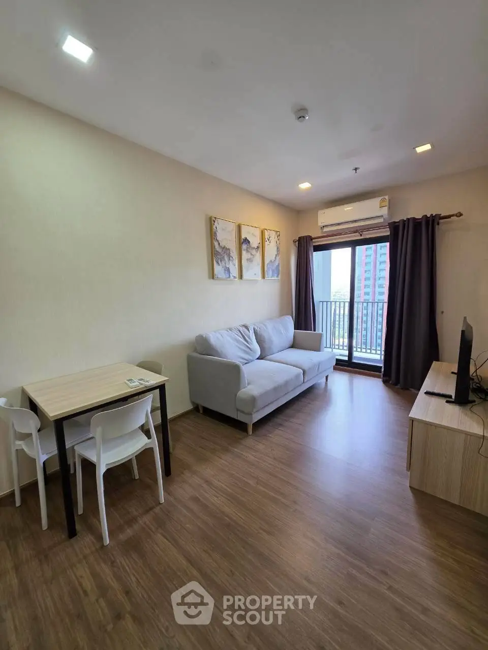 Modern living room with cozy sofa, dining table, and balcony view in a stylish apartment.