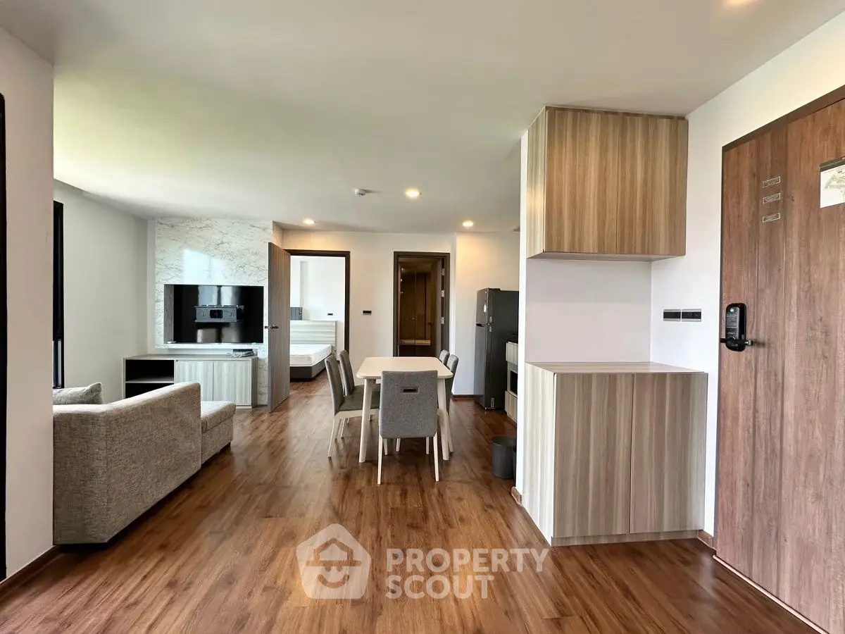Spacious modern apartment with open layout, wooden flooring, and stylish furniture, perfect for urban living.