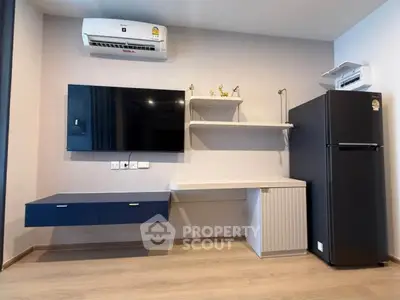Modern living room with sleek furniture, wall-mounted TV, and air conditioning unit.
