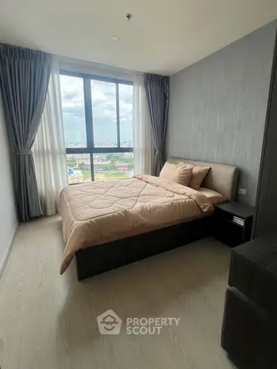 Modern bedroom with large window offering stunning city view, featuring cozy bed and elegant decor.