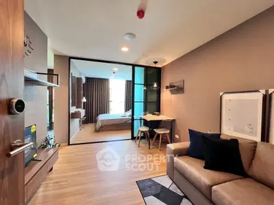 Modern open-plan living room with cozy seating and stylish bedroom view
