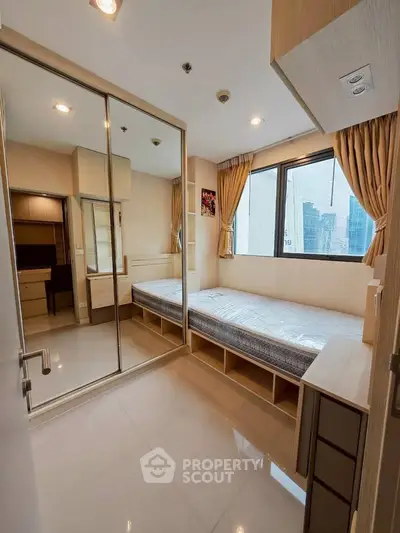 Modern bedroom with mirrored closet and city view, featuring sleek design and ample natural light.