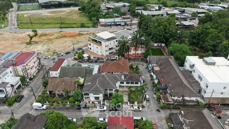 Aerial view of residential neighborhood with lush greenery and diverse architecture.