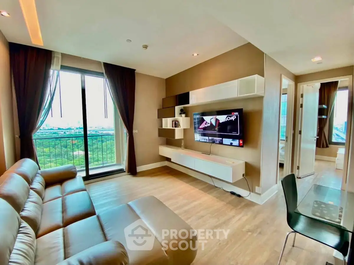 Modern living room with sleek furniture and large window offering a stunning view.