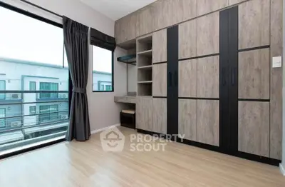 Spacious bedroom with large window and modern built-in wardrobe