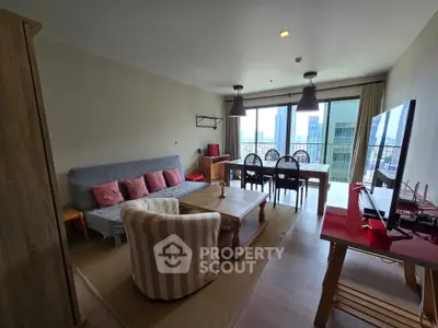 Spacious living room with modern decor and city view balcony, perfect for urban living.