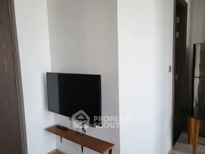 Modern living room with wall-mounted TV and sleek wooden shelf