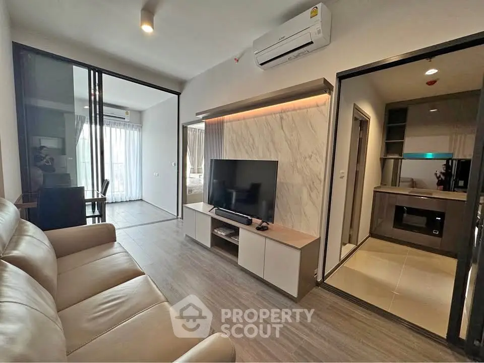 Modern living room with sleek design, featuring a large TV, comfortable seating, and stylish decor.