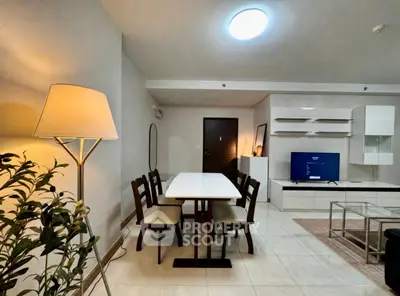 Modern living room with dining area, stylish furniture, and ambient lighting.