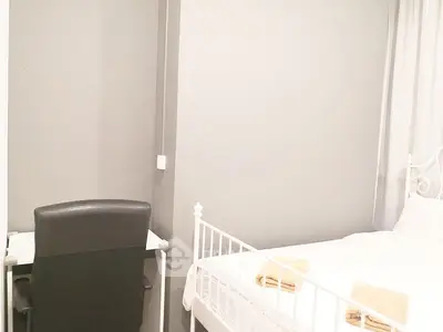 Cozy bedroom with modern desk and elegant white bed frame, perfect for relaxation and productivity.