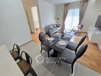 Modern living room with dining area, featuring elegant furniture and natural light.