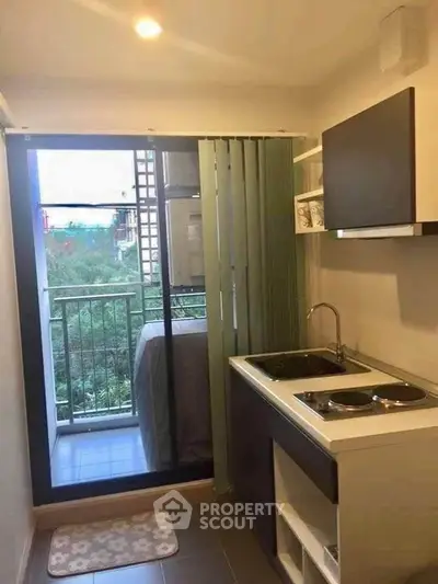 Compact kitchen with balcony view in modern apartment