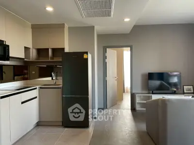 Modern open-plan kitchen and living room with sleek appliances and stylish decor.
