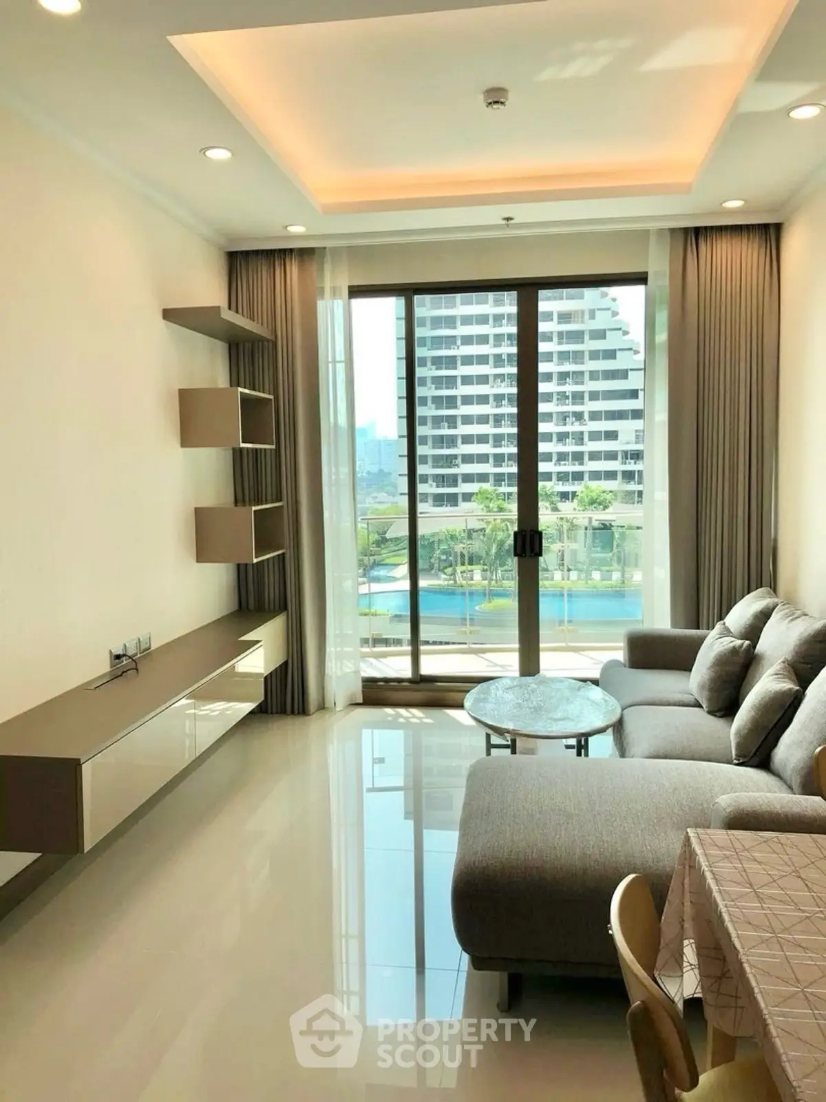 Modern living room with large windows and pool view in luxury apartment