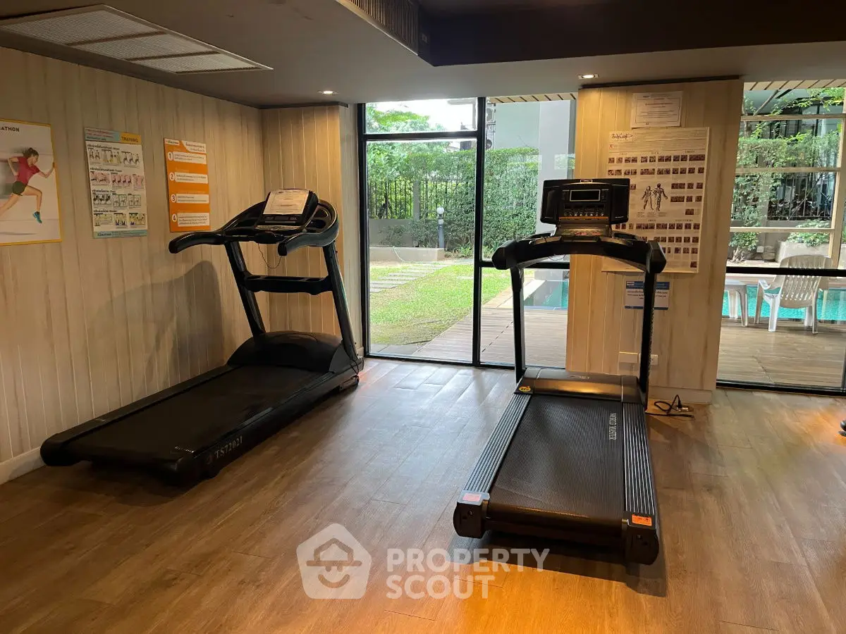 Modern gym with treadmills and pool view, perfect for fitness enthusiasts.