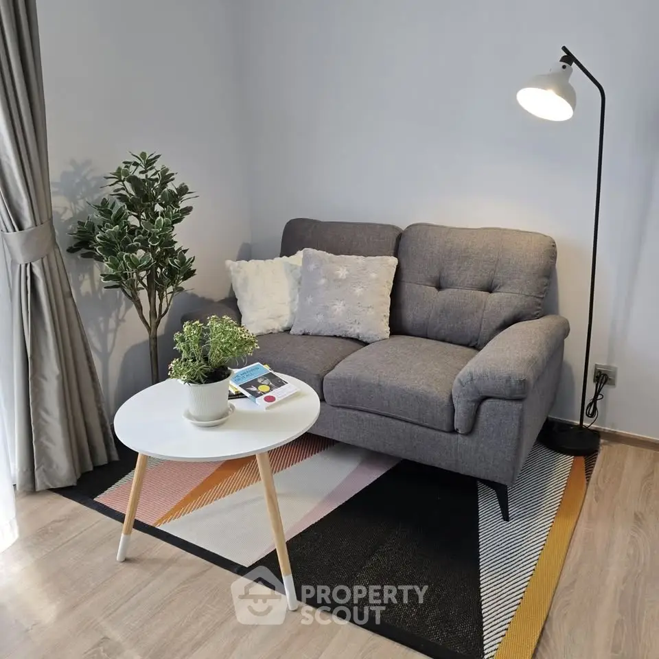 Cozy living room with stylish gray sofa, modern floor lamp, and chic decor accents.