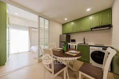 Modern kitchen with green cabinets and dining area in open layout apartment