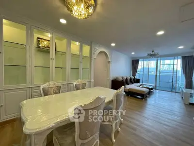 Luxurious living room with elegant dining area and spacious seating, featuring large windows and stylish decor.