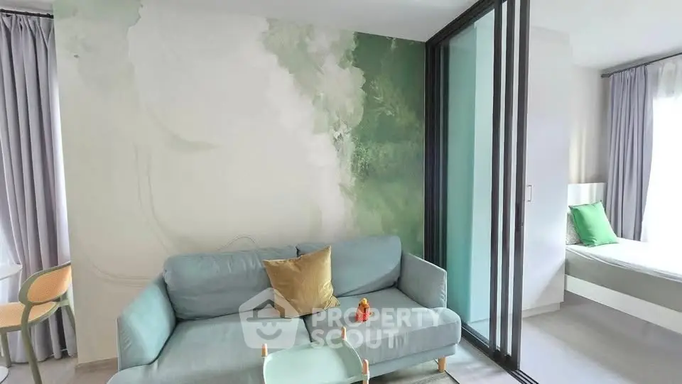 Modern living room with stylish sofa and sliding glass partition to bedroom