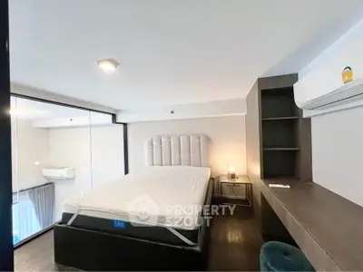 Modern bedroom with sleek design, featuring a comfortable bed, built-in desk, and air conditioning unit.