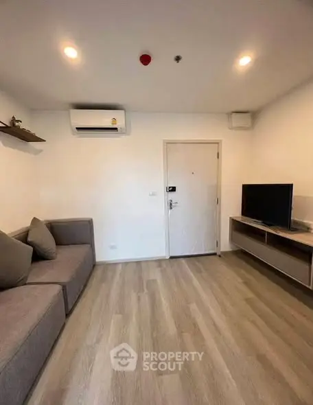 Modern living room with sleek design, featuring a comfortable sofa and wall-mounted TV unit.