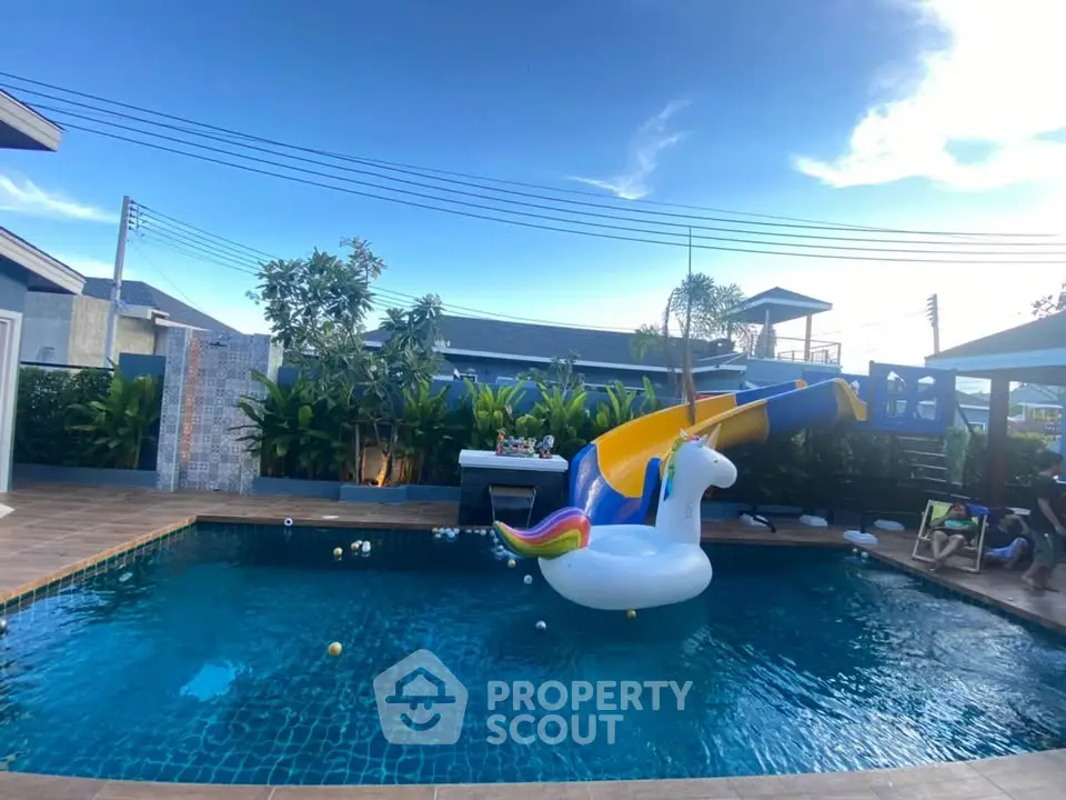 Luxurious outdoor pool with unicorn float and slide, perfect for family fun and relaxation.