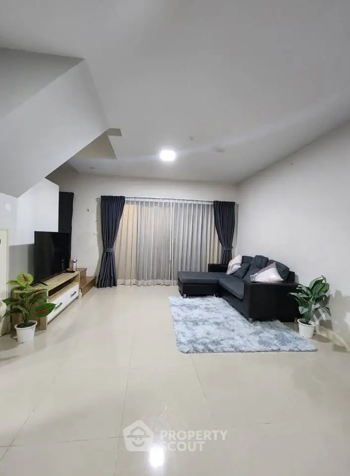 Spacious modern living room with sleek furniture and large windows for natural light.