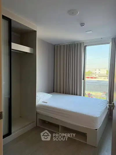 Cozy bedroom with large window and built-in closet, perfect for natural light lovers.