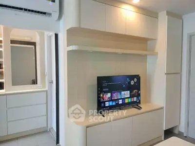 Modern living room with built-in shelves and flat-screen TV, showcasing sleek design and efficient use of space.