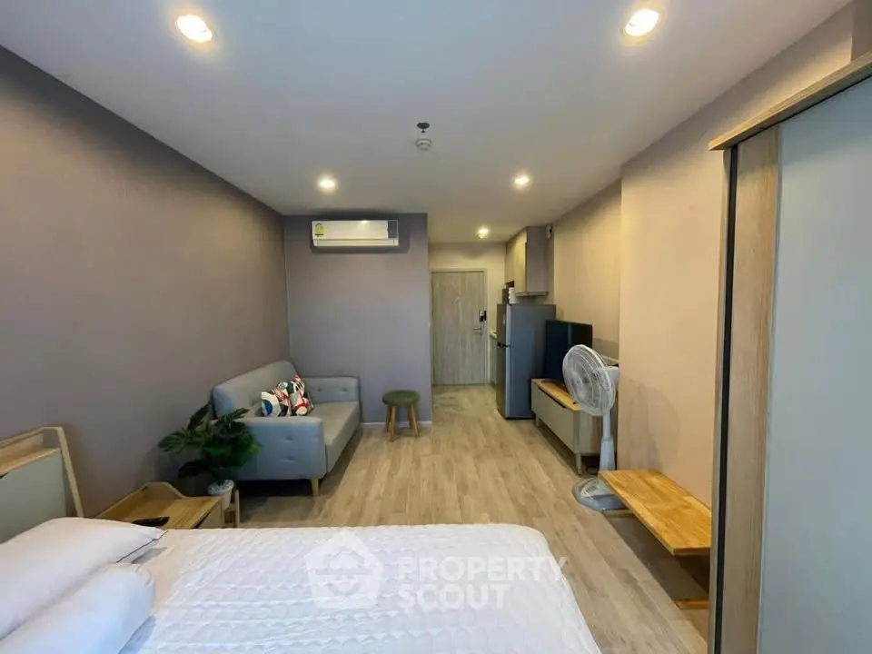 Modern studio apartment with cozy living area and sleek furnishings, perfect for urban living.