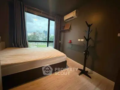 Modern bedroom with large window and air conditioning in urban apartment