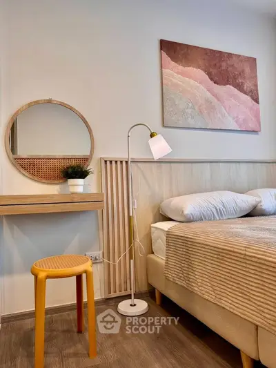 Cozy bedroom with modern decor, featuring a stylish bed, elegant lamp, and chic wall art.