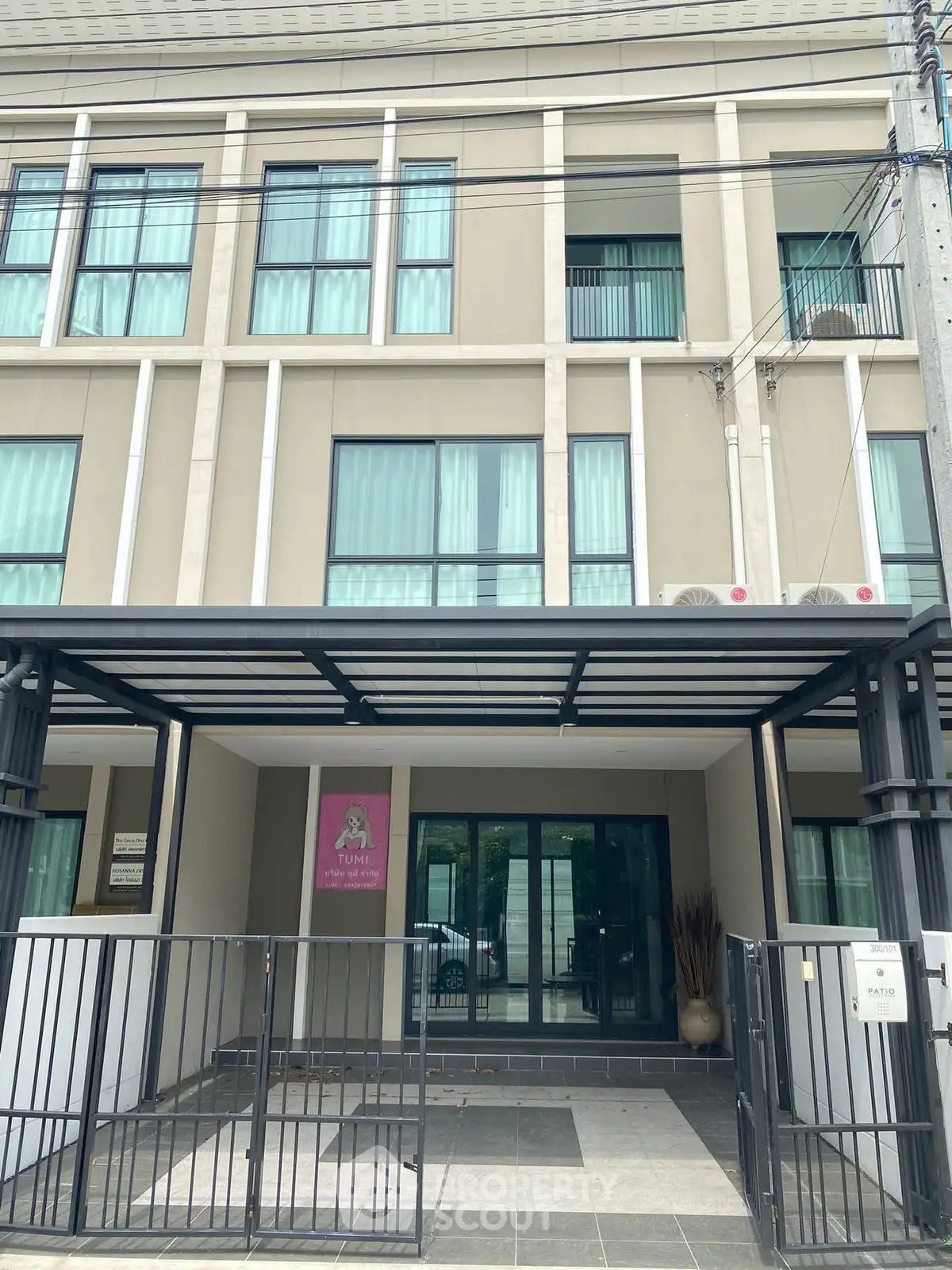 Modern building facade with gated entrance and large windows