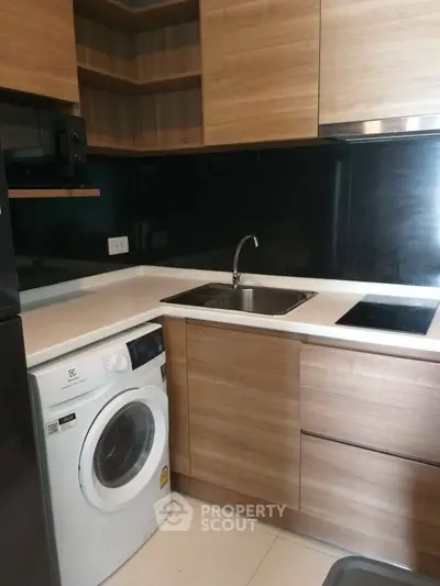 Modern kitchen with sleek wooden cabinets and built-in washing machine