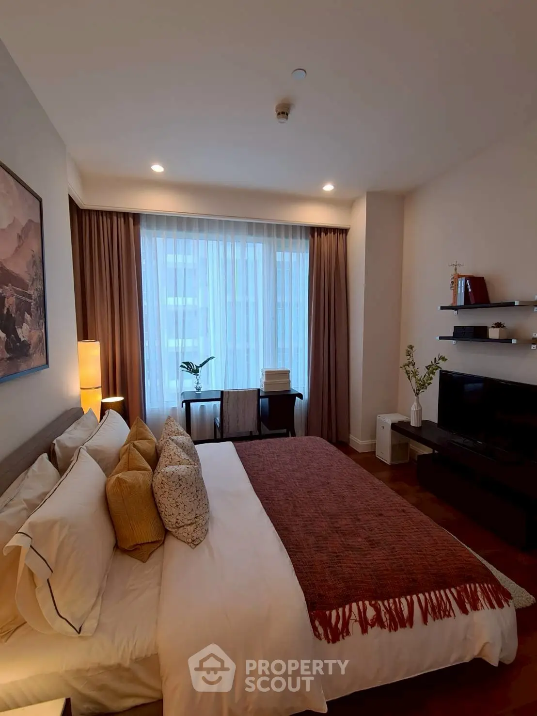Elegant bedroom with cozy decor and natural light, featuring a stylish bed and modern furnishings.