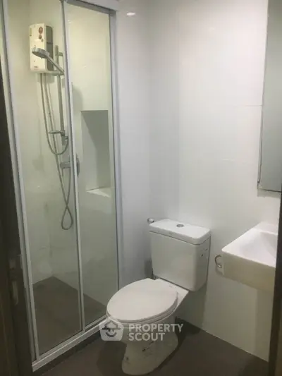 Modern bathroom with shower enclosure and sleek fixtures in a contemporary apartment.
