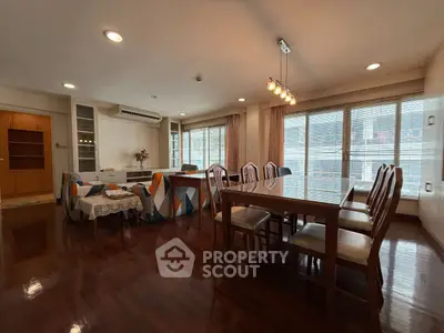 Spacious living and dining area with elegant wooden flooring and ample natural light.