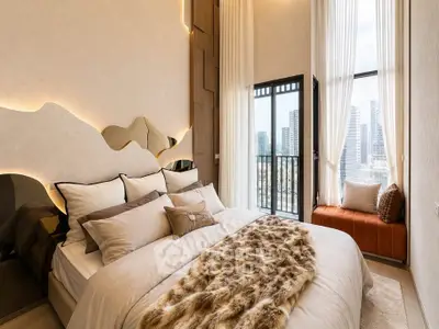 Luxurious bedroom with modern decor and city view from balcony, featuring plush bedding and stylish lighting.