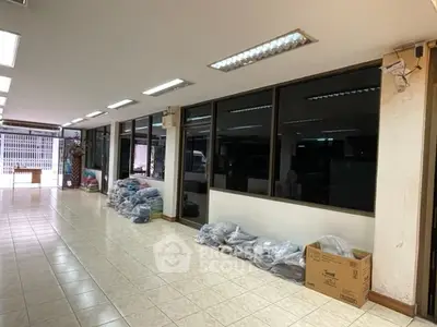 Spacious commercial space with tiled flooring and large windows for lease.