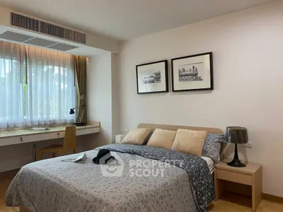Cozy bedroom with stylish decor and natural light, featuring a comfortable bed and a work desk by the window.