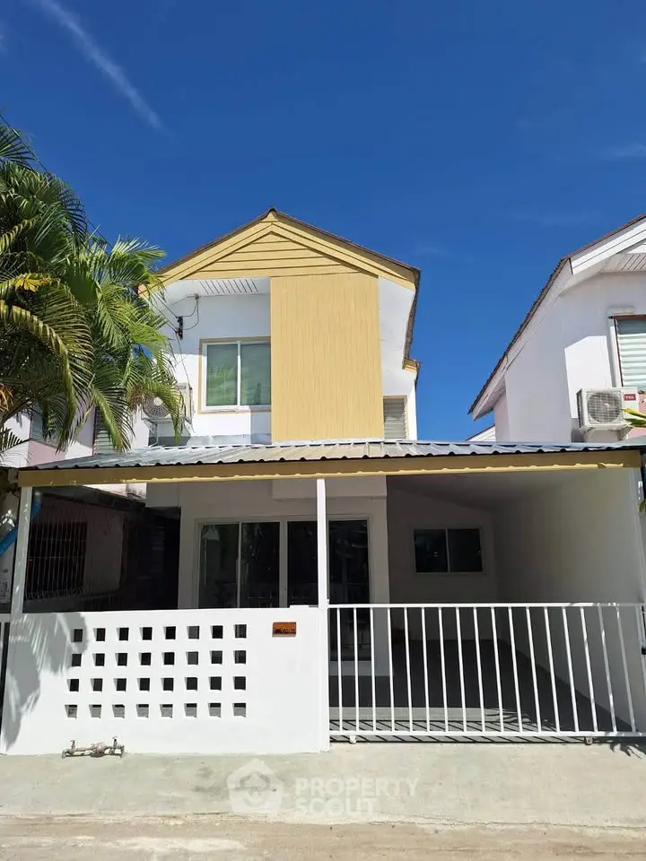 Charming two-story house with modern facade and spacious driveway under clear blue sky.