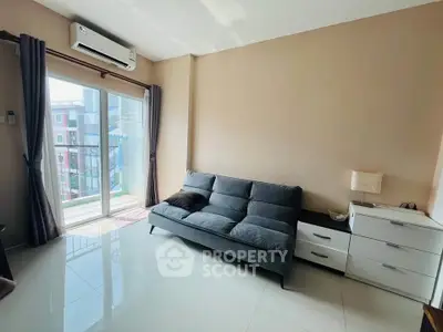 Modern living room with sleek sofa and balcony view in a bright apartment.