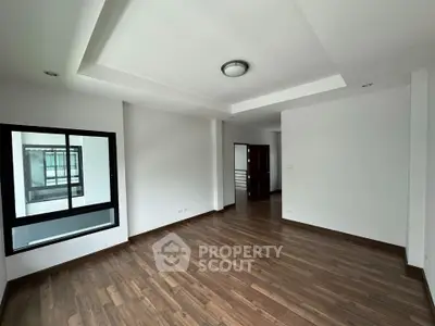 Spacious modern living room with wooden flooring and large window