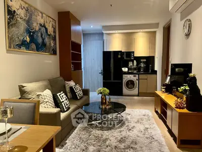 Modern living room with stylish decor, cozy seating, and integrated kitchen appliances in a chic apartment.