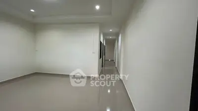 Spacious empty room with glossy tiled floors and recessed lighting