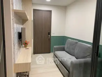Cozy living room with modern sofa and wall-mounted TV, perfect for relaxation.